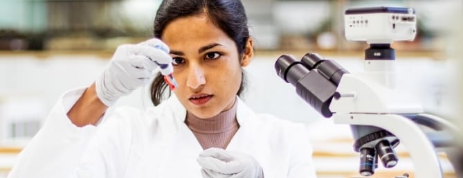 lab scientist looking at a tube