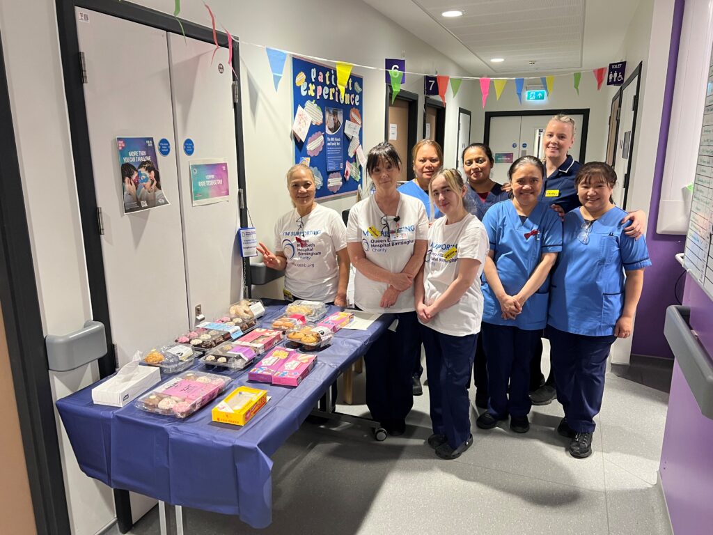 Members of the team in the Rare Diseases Centre at Queen Elizabeth Hospital Birmingham next to a table with cakes. 